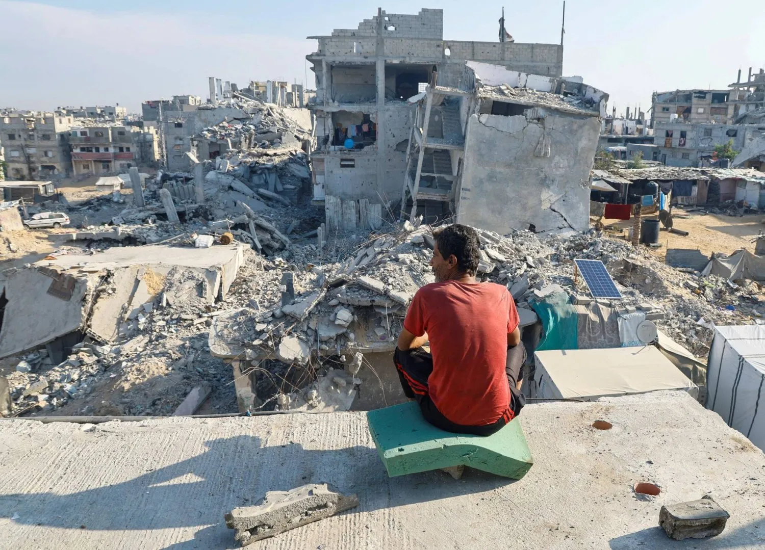 Gazze Şeridi'ndeki Han Yunus'ta İsrail bombardımanında yıkılan bir evin enkazındaki Filistinli (Reuters)