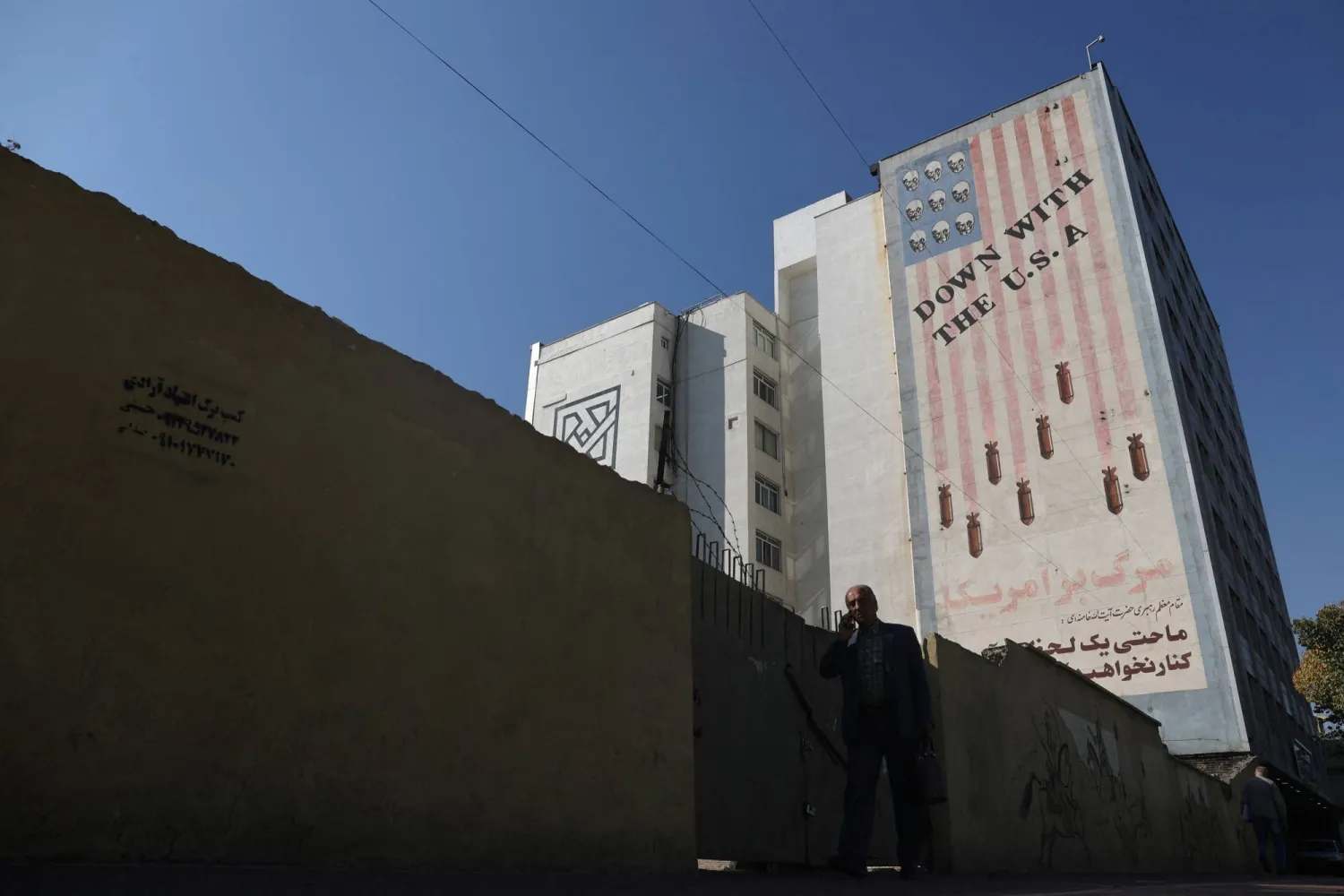 An Iranian man passes in front of an anti-US mural on a street in Tehran, Iran November 6, 2024. Majid Asgaripour/WANA (West Asia News Agency) via REUTERS 