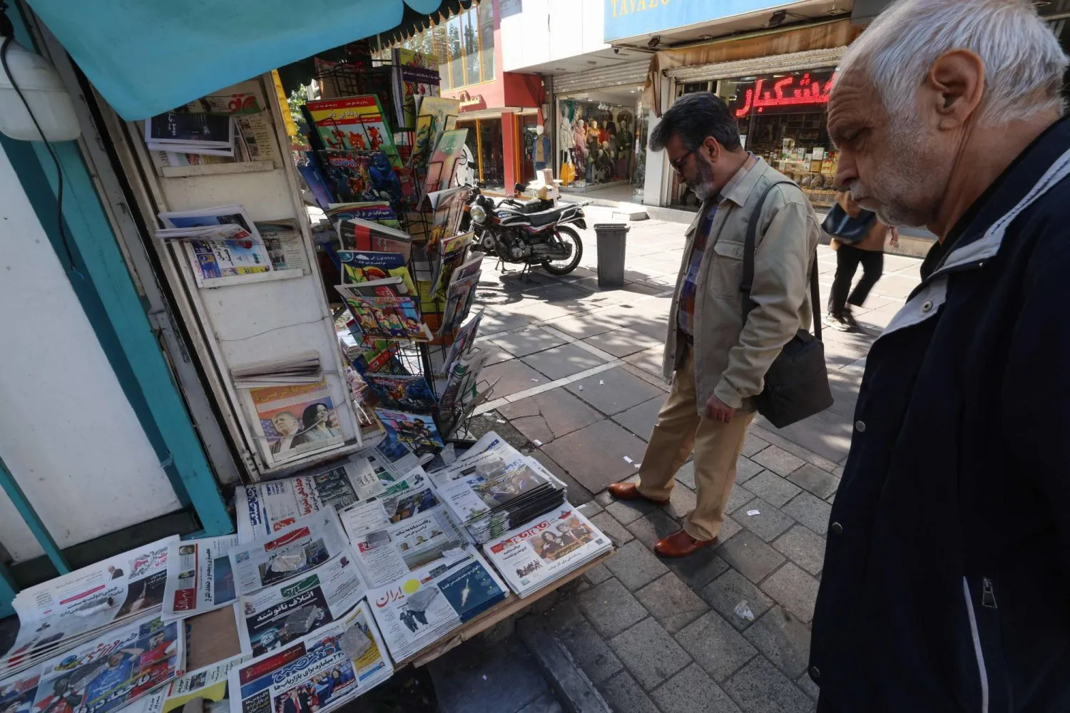 ABD başkanlık seçimi sonuçlarının açıklanmasının ardından Tahran'da yerel gazetelerin manşetlerine göz atan İranlılar (AFP)