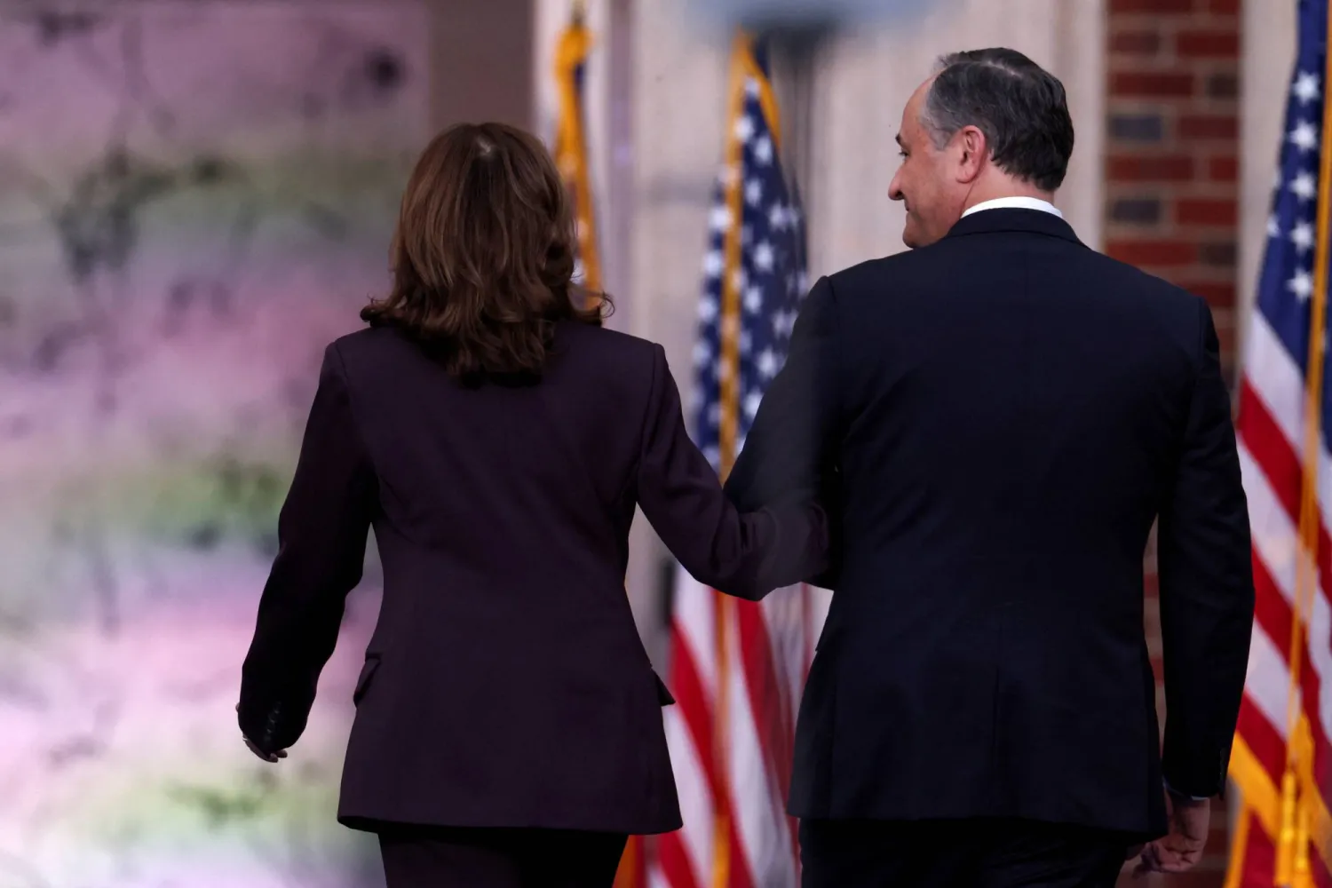 كامالا هاريس وزوجها النائب الثاني دوج إمهوف يغادران المسرح بعد أن ألقت كلمتها (رويترز)