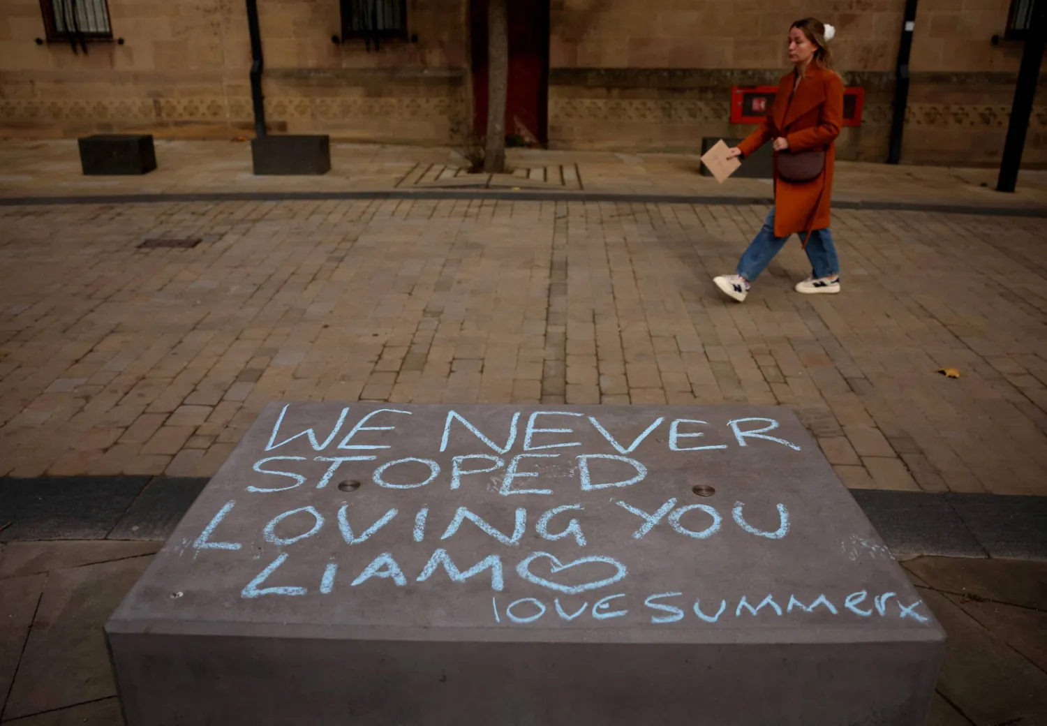 FILE PHOTO: A woman passes by a message written as a tribute to former One Direction singer Liam Payne, who was found dead after he fell from a third-floor hotel room balcony in Buenos Aires, in Manchester, Britain, October 21, 2024. REUTERS/Phil Noble/File Photo