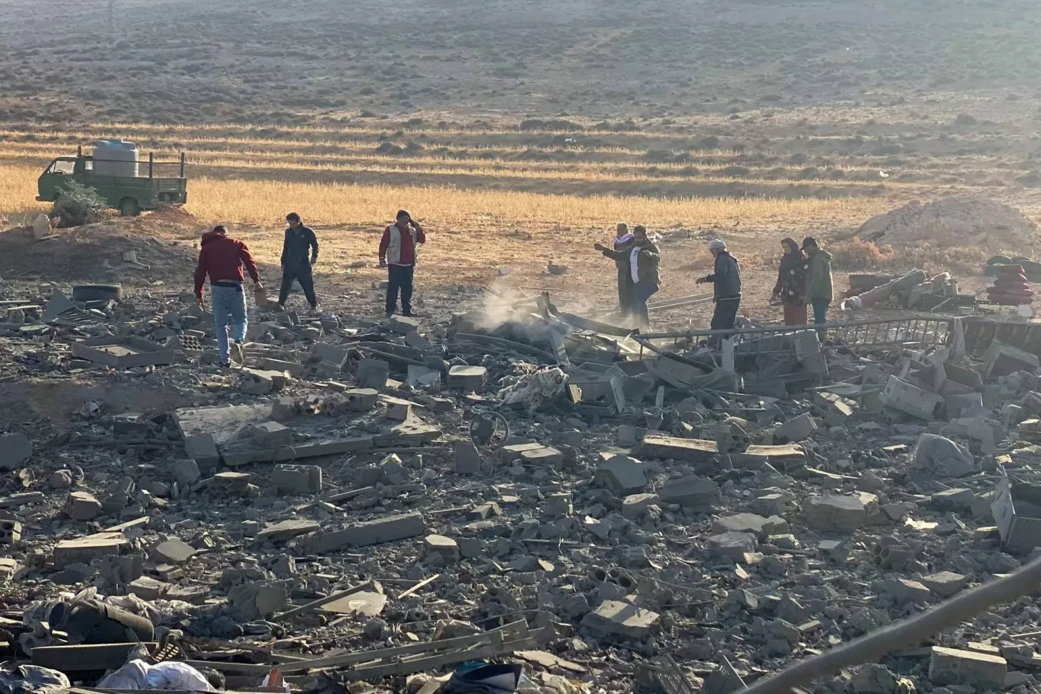 Lübnan'ın Baalbek kenti yakınlarındaki el-Ayn köyünü hedef alan İsrail hava saldırısının gerçekleştiği bölgede yaşayanlar yıkımı inceliyor. (AFP)