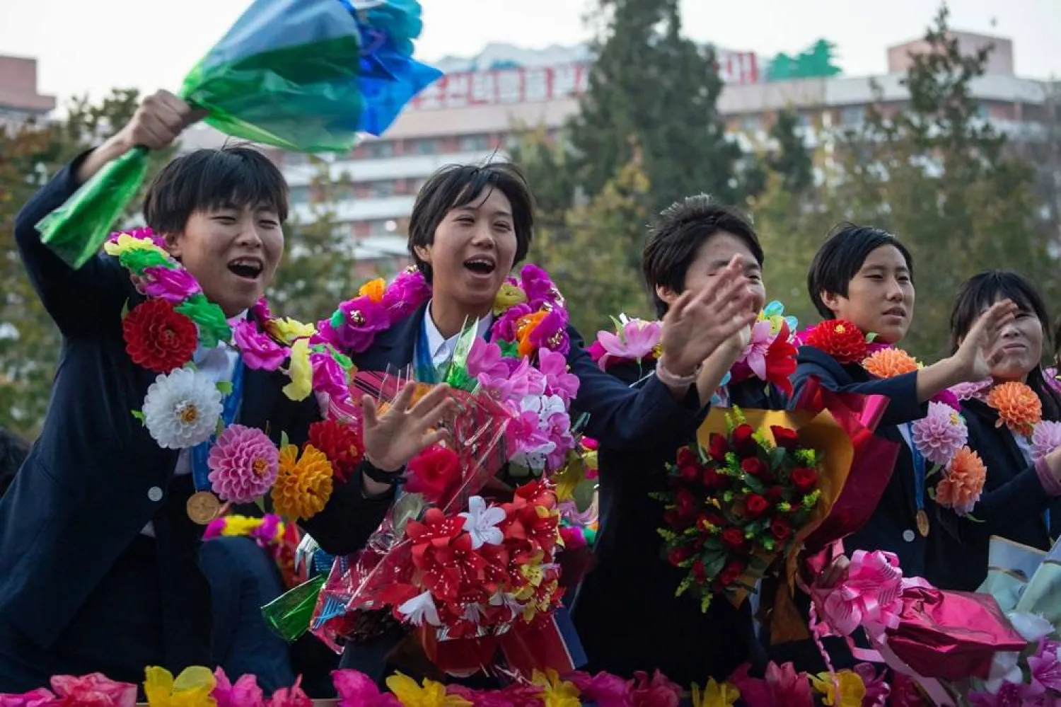 Members of the North Korean women's under-17 football team wave to people after their arrival in Pyongyang on November 9, 2024. (AFP)