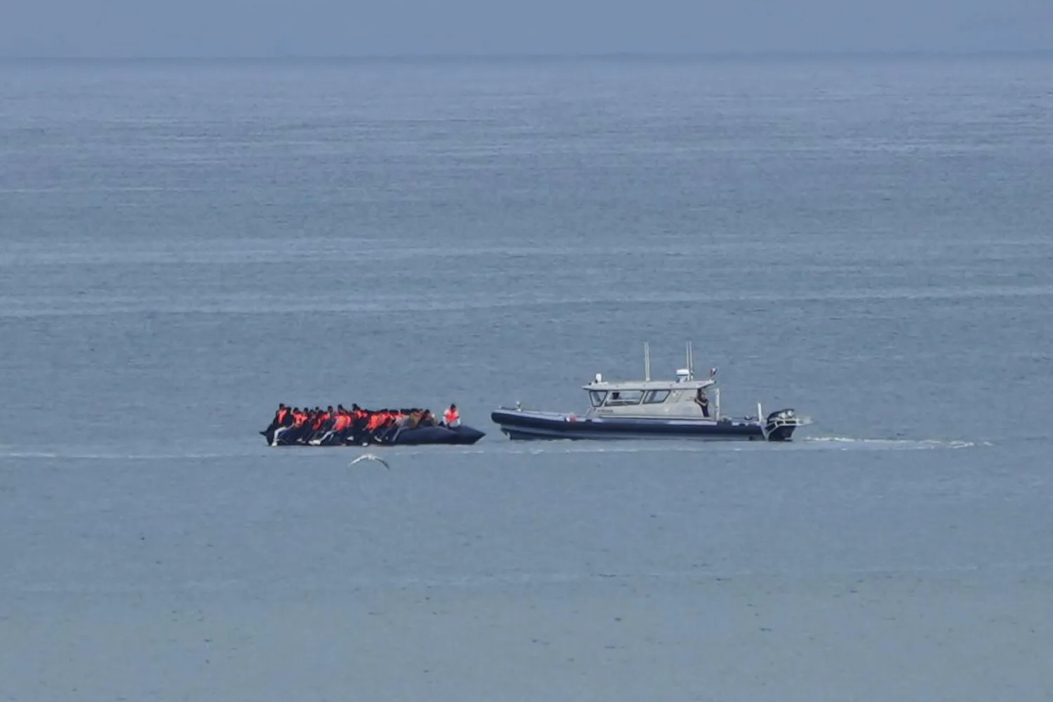FILE - A boat thought to carry migrants is escorted by a vessel from the French Gendarmerie Nationale in the English Channel off Wimereux beach, France, Wednesday, Sept. 4, 2024. (AP Photo/Nicolas Garriga, File)