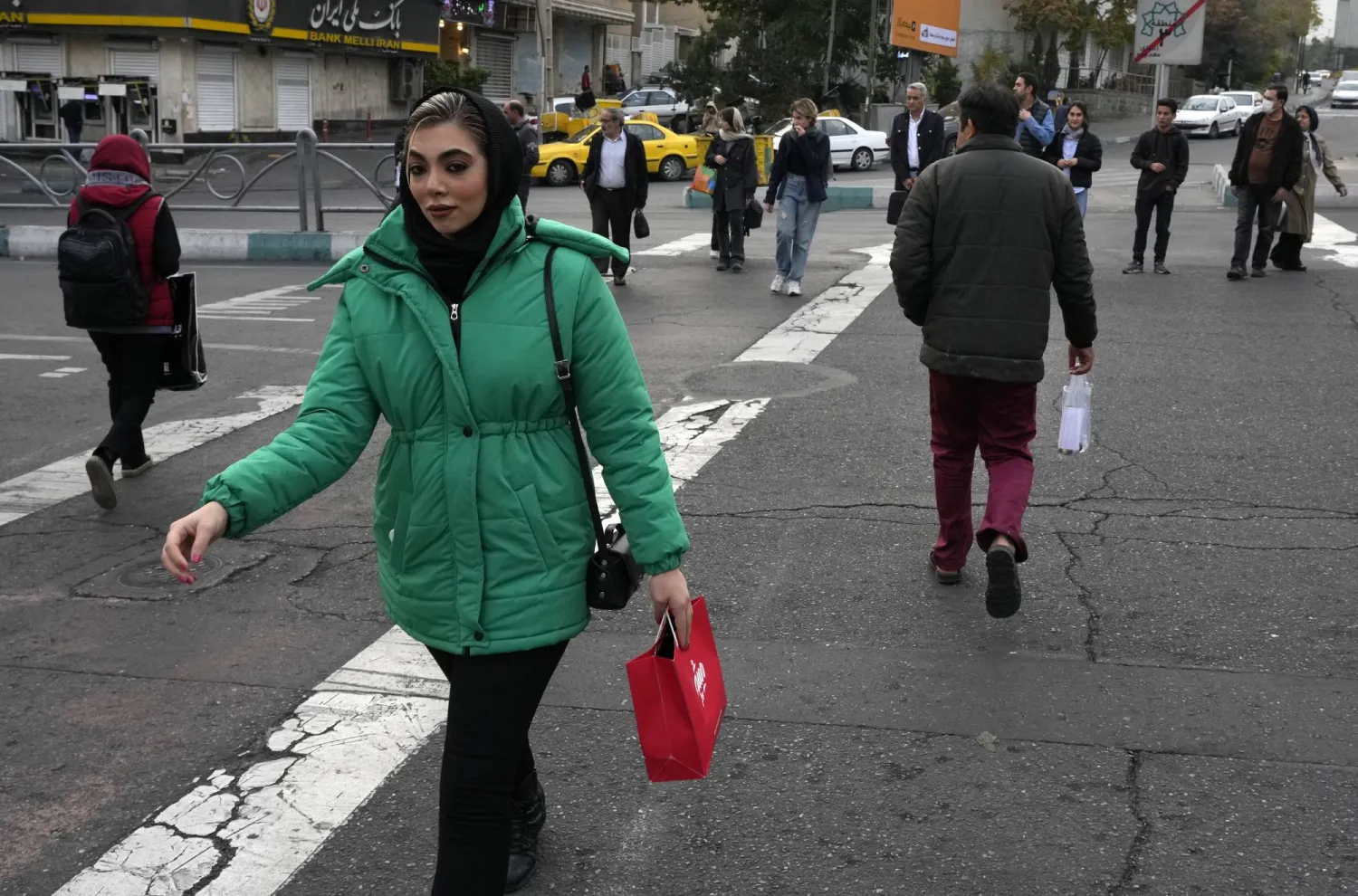 People cross an intersection in northern Tehran, Iran, Thursday, Nov. 7, 2024. (AP Photo/Vahid Salemi)