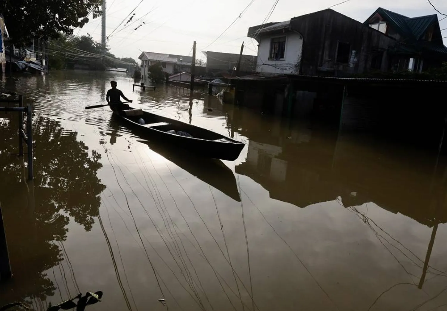 A villager on a wooden boat paddles on a flooded village caused by Typhoon Toraji in Tuguegarao city, Cagayan city, Philippines, 13 November 2024. (EPA)