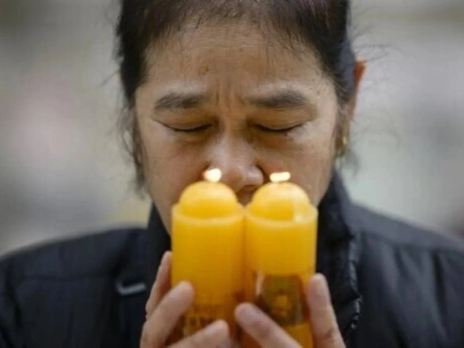 A woman prays at Seoul's Jogyesa Buddhist temple, where prayers are being held for students taking the university entrance exam. ANTHONY WALLACE / AFP
