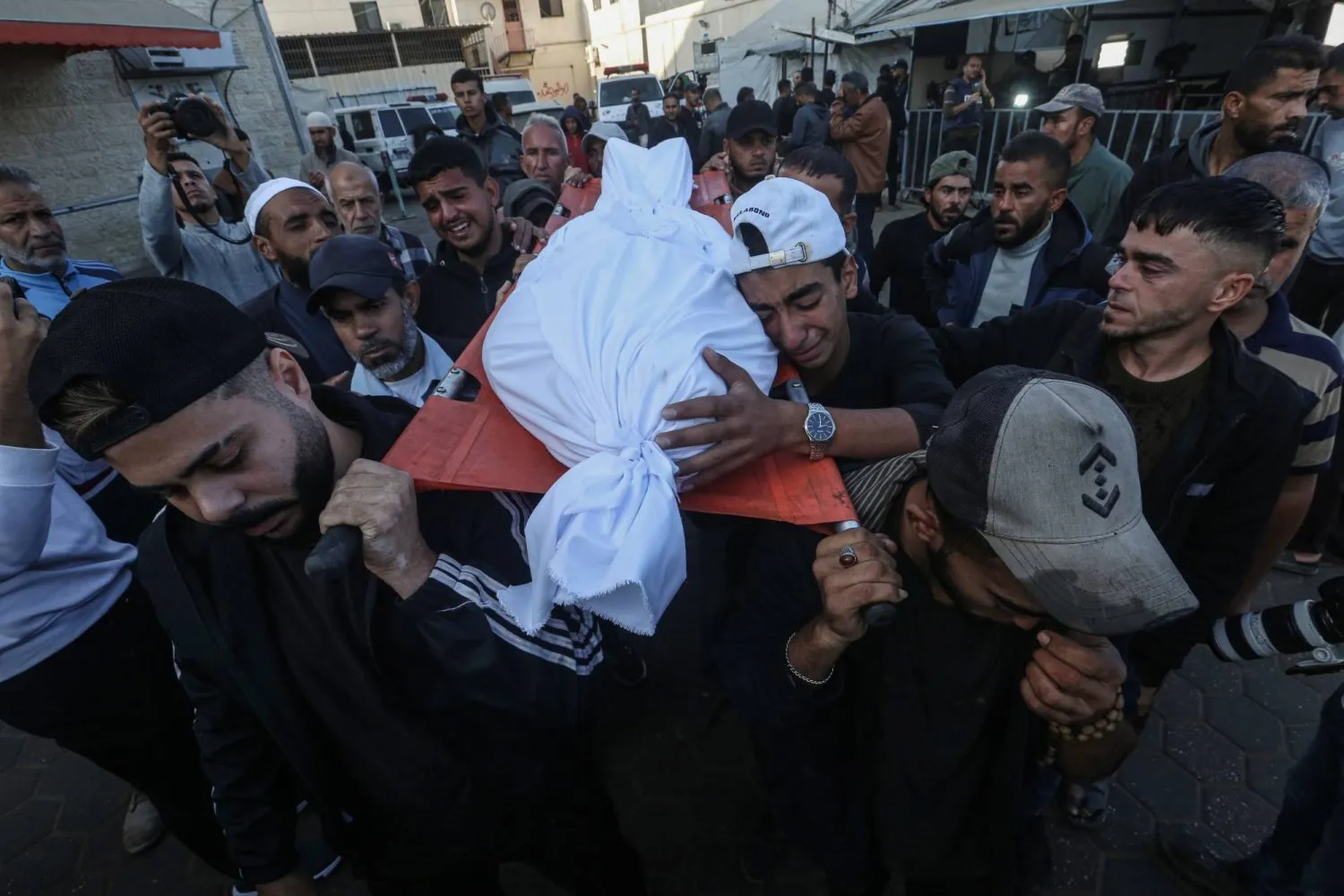 İsrail'in Gazze Şeridi'nin merkezindeki çeşitli bölgelere düzenlediği bombardımanda öldürülen Filistinlilerin yakınları, cenazelerini duygu dolu bir şekilde taşıyor (DPA)