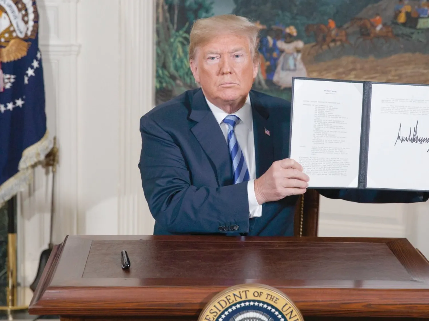 ترمب يعرض مذكرة وقّعها للانسحاب من الاتفاق النووي الإيراني في 8 مايو 2018 (أ.ب)