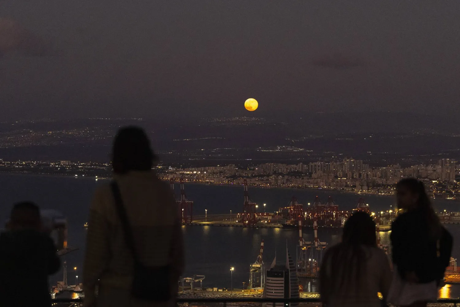 ظهور القمر بالقرب من الحدود بين إسرائيل ولبنان كما يُرى من خليج حيفا (أ.ب)