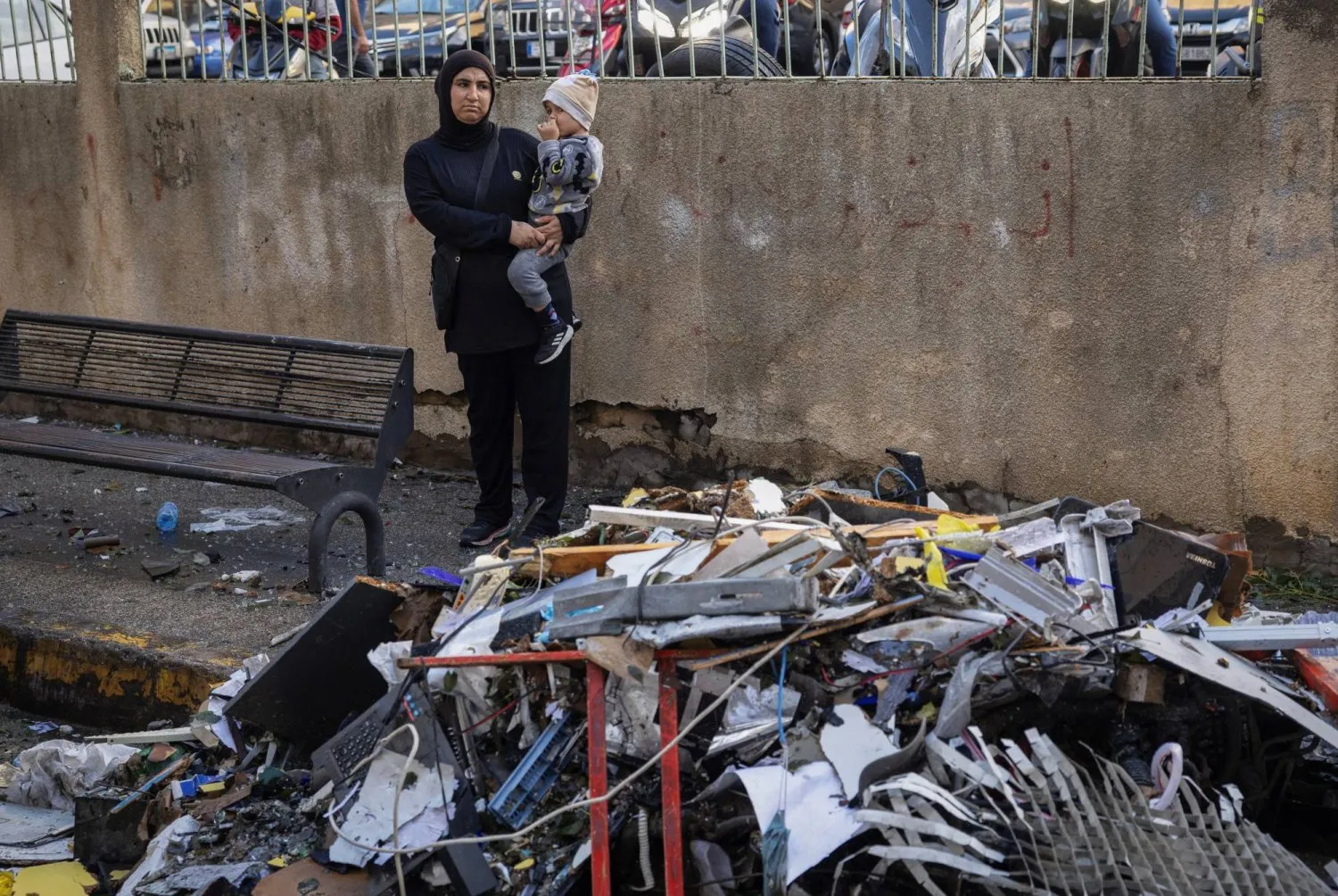 Beyrut'taki Mar Elias Caddesi'nde İsrail saldırısının ardından hasar gören bir binanın enkazı önünde duran bir kadın ve çocuğu (Reuters)
