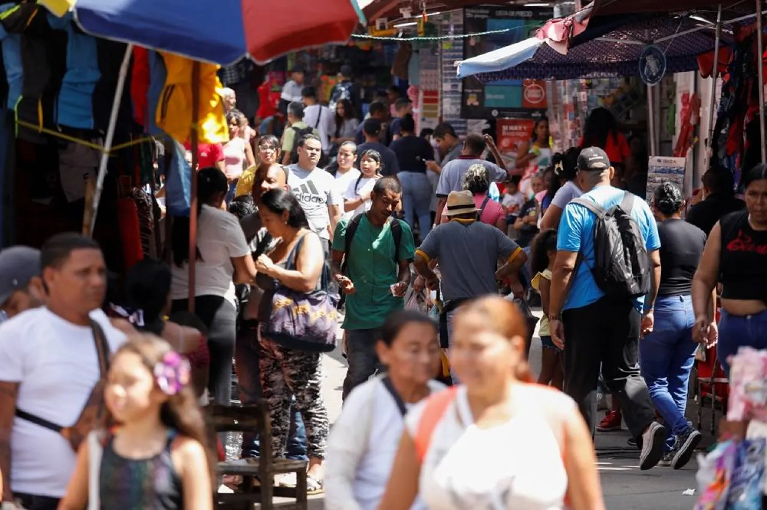 People walk through a market in the low-income Petare neighborhood, in Caracas, Venezuela November 16, 2024. (Reuters) 