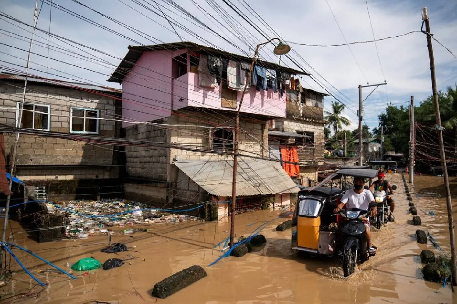  People ride motorized tricycles on a flooded street following super typhoon Man-yi, in Cabanatuan, Nueva Ecija, Philippines, November 18, 2024. (Reuters)