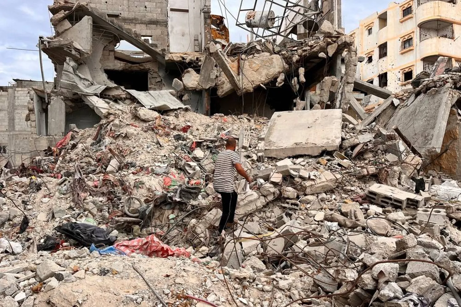  Palestinian man Moein Abu Odeh searches for clothes through the rubble of a house destroyed in the Israeli military offensive, in Khan Younis in the southern Gaza Strip, November 18, 2024. (Reuters)