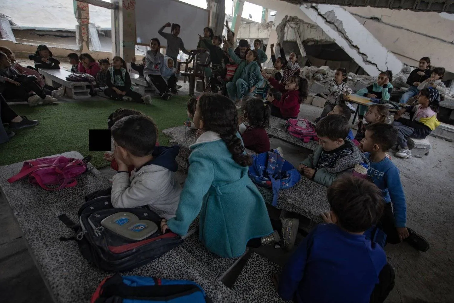 Palestinian children sit in a classroom amid the rubble of a destroyed school in the Khan Younis camp, southern Gaza Strip. (EPA)