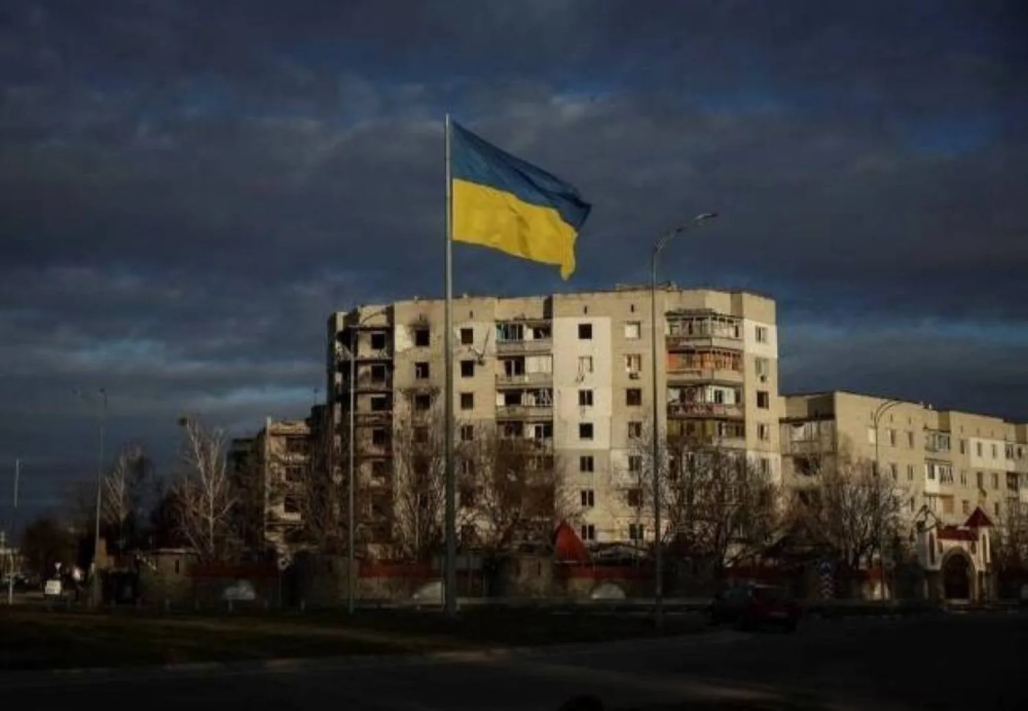 A Ukrainian national flag flutters near buildings destroyed by Russian military strikes in Borodianka, Ukraine, February 15, 2023. (Reuters)