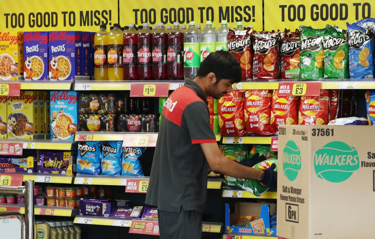 موظف في سوبر ماركت يقوم بتحميل الرفوف (إ.ب.أ)