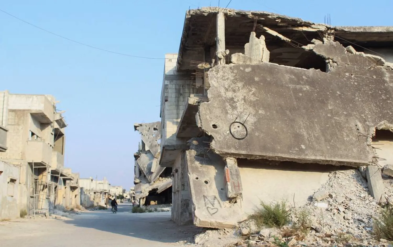  A man rides a motorbike past damaged buildings in Homs, Syria November 7, 2024. (Reuters)