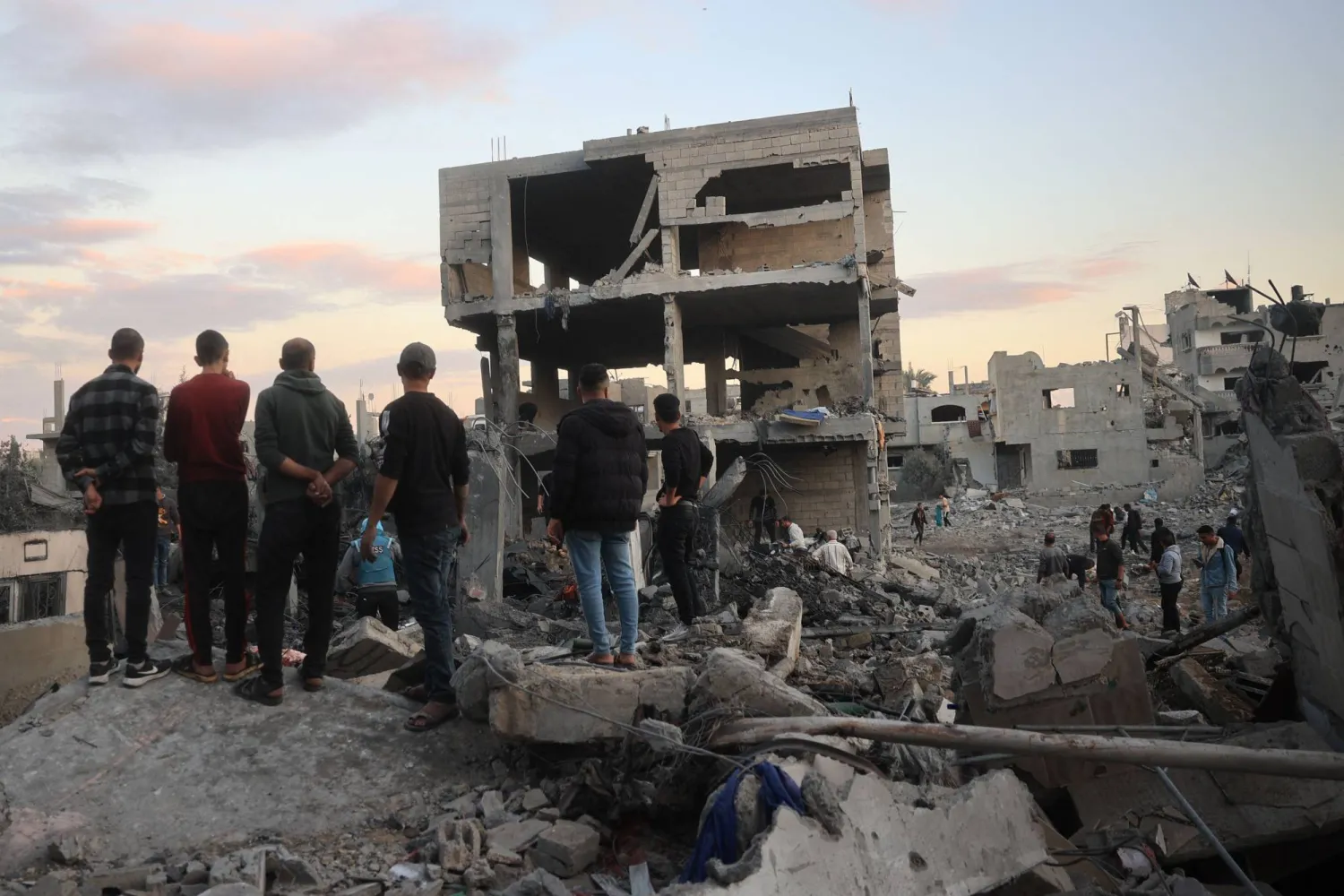 فلسطينيون يتفقدون الدمار في موقع غارة جوية إسرائيلية على مخيم البريج للاجئين في وسط قطاع غزة (رويترز)