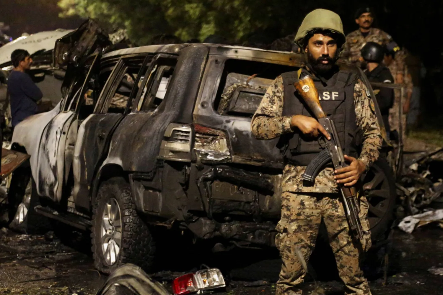 FILE PHOTO: A member of the Airport Security Force ASF stands guard near the wreckage of vehicles after an explosion near Jinnah International Airport in Karachi, Pakistan October 6, 2024. REUTERS/Shakil Adil/File Photo