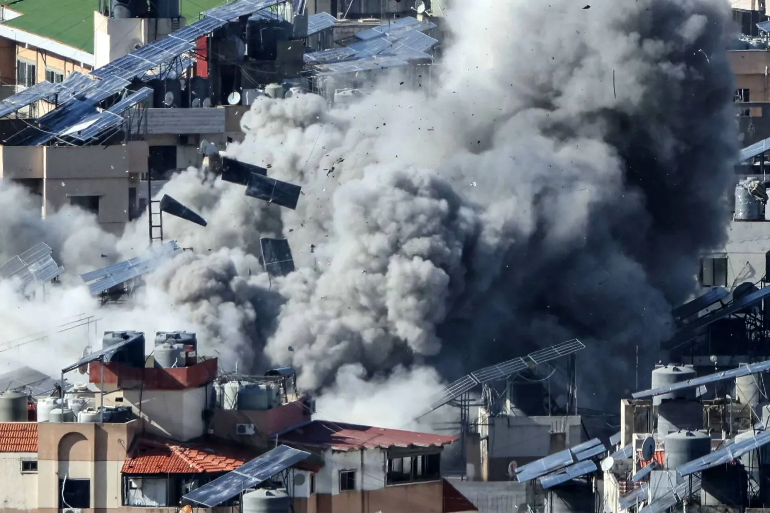أجسام تتطاير وسط دخان كثيف خلال غارة جوية إسرائيلية استهدفت الضاحية الجنوبية لبيروت (أ.ف.ب)