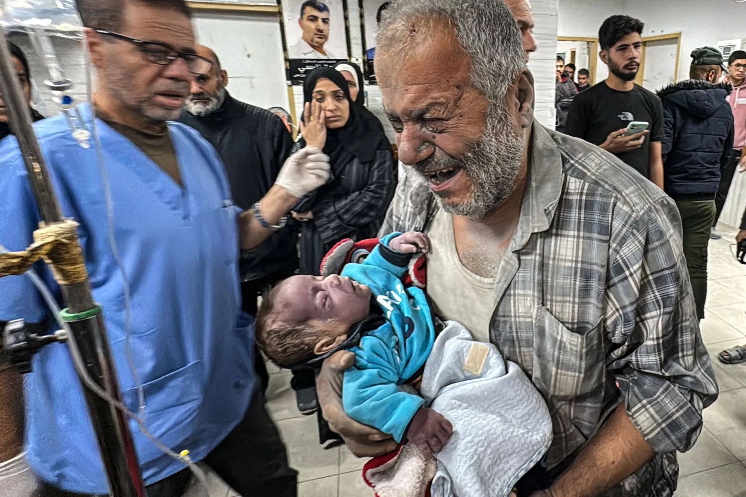 A Palestinian man reacts as he carries a young victim inside the Kamal Adwan hospital following an Israeli strike that hit an area near the medical establishment in Beit Layia in the northern Gaza Strip early on November 21, 2024, reportedly leaving dozens of people killed or unaccounted for. (Photo by AFP)