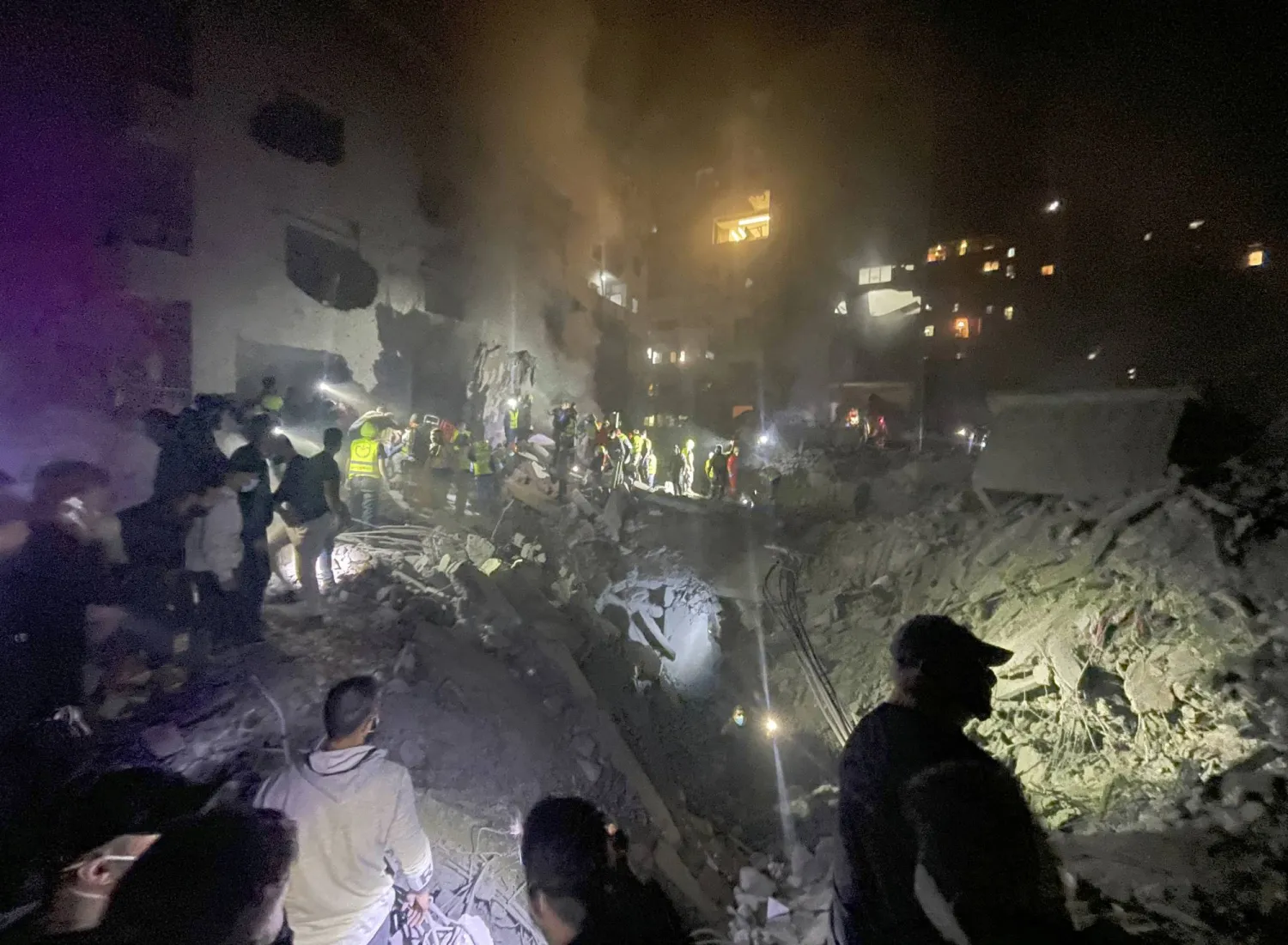 Arama kurtarma görevlileri ve bölge sakinleri, Beyrut'ta İsrail saldırısının gerçekleştiği yerde enkaz altında kalanları arıyor (AP)