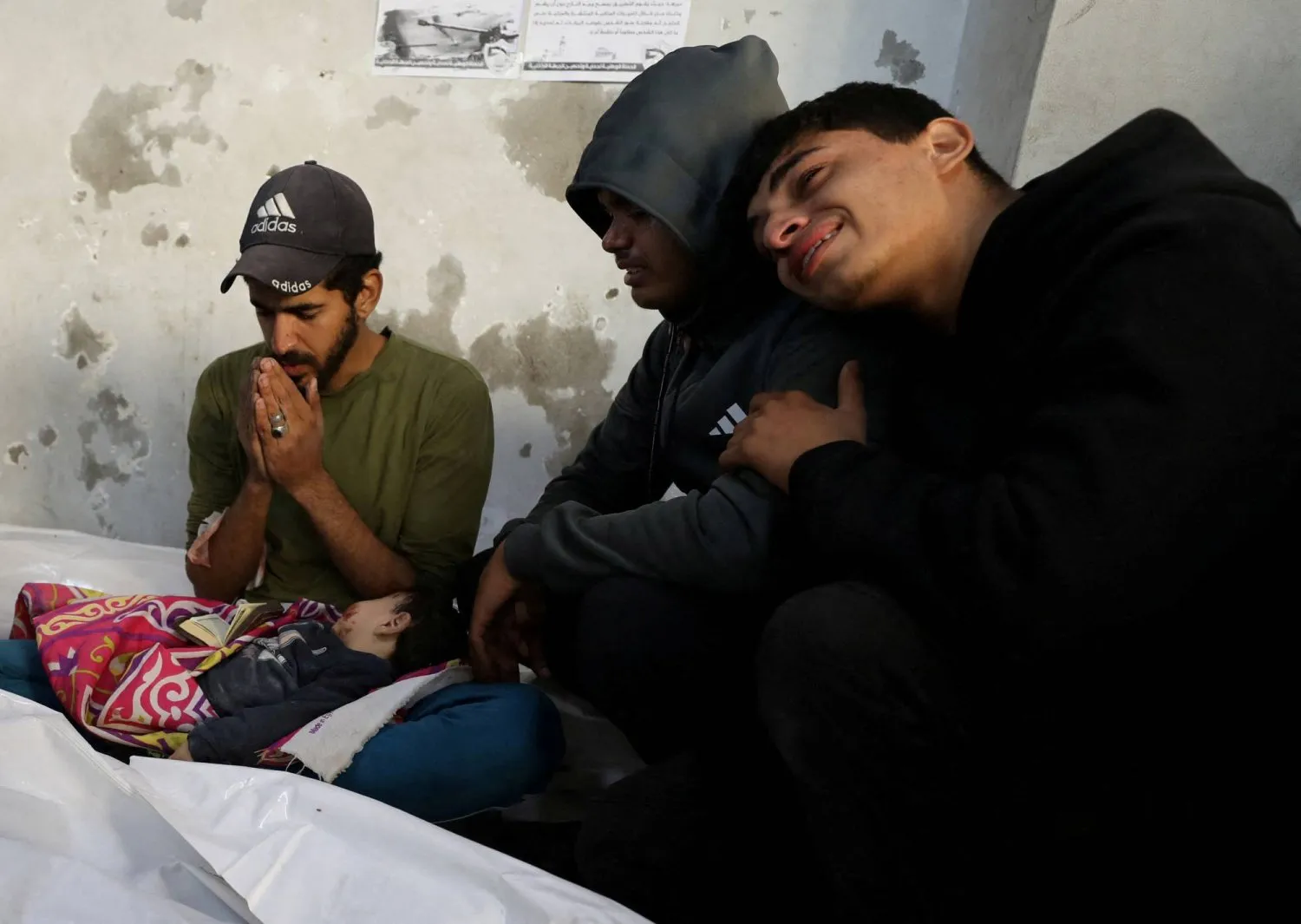 Gazze Şeridi'ndeki İsrail saldırısında hayatını kaybeden yakınlarının cenazeleri başında yas tutan Filistinliler (Reuters)