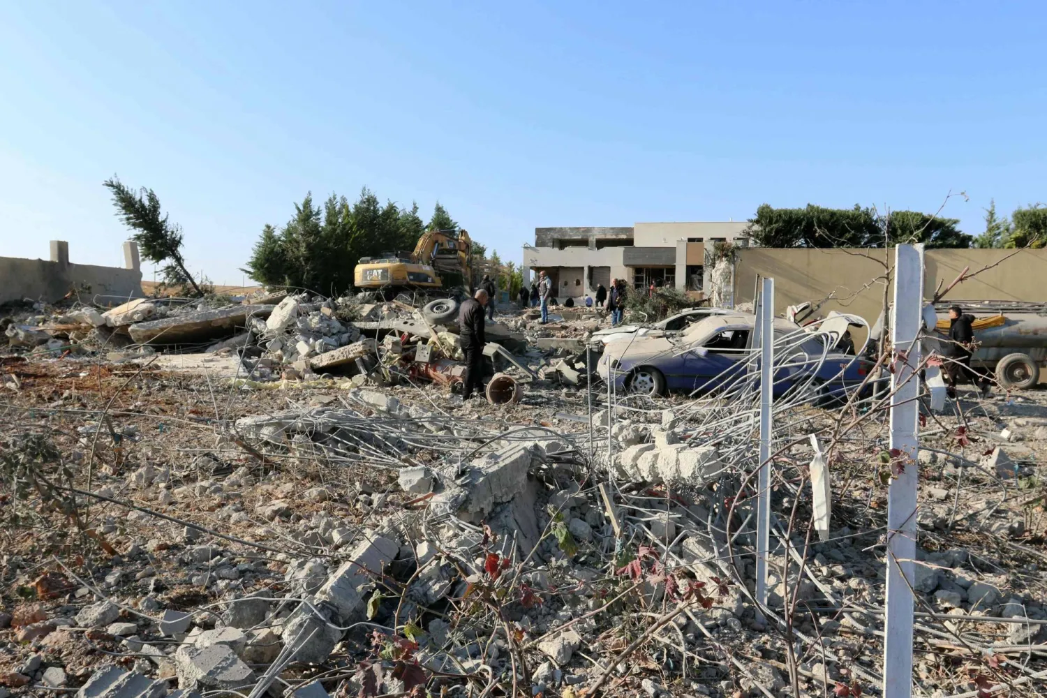 عمال يزيلون الأنقاض من موقع غارة جوية إسرائيلية على احد المنازل في بعلبك (أ.ف.ب)