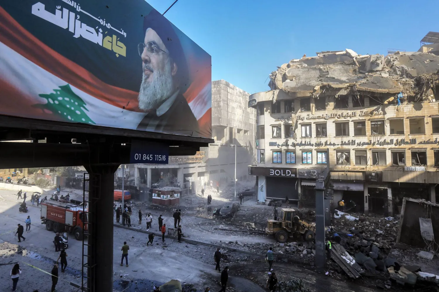 صورة لأمين عام «حزب الله» السابق حسن نصر الله قرب موقع الاستهداف في الشياح (أ.ف.ب)