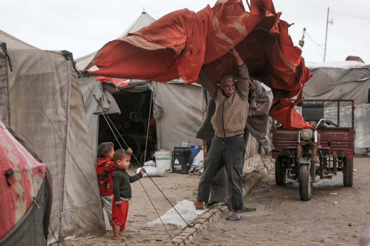 أمطار الليلة الماضية أغرقت الخيام القماشية وبللت أغطية يفترشها النازحون (أ.ف.ب)