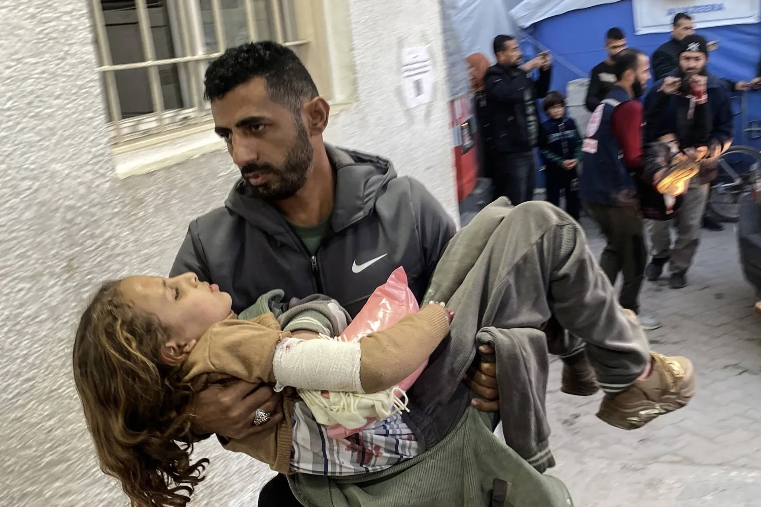 فلسطيني يحمل طفلة مصابة في غزة (د.ب.أ)