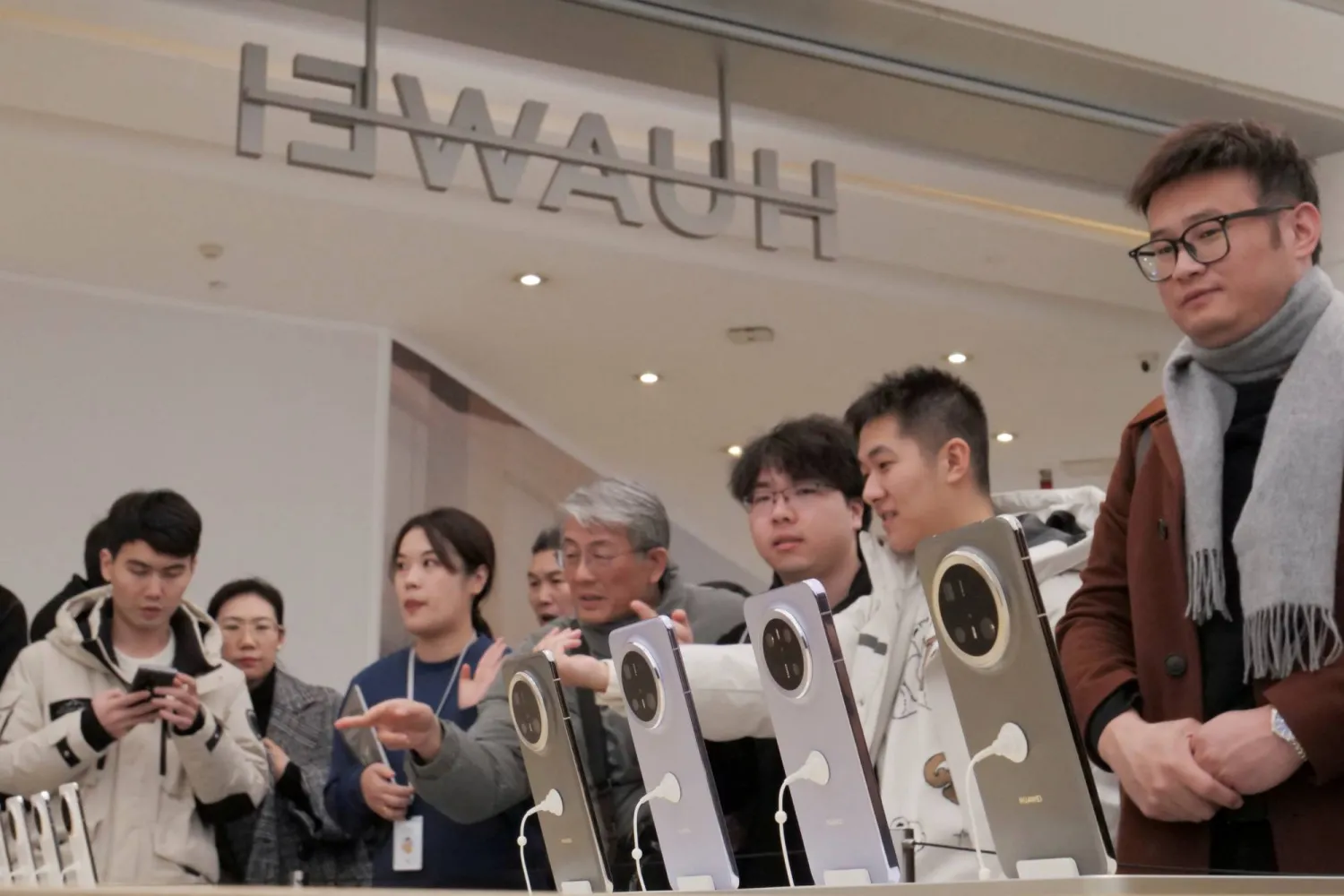 Visitors look at Huawei's newly unveiled Mate 70 smartphone series at a flagship store in Beijing, China November 26, 2024. REUTERS/Xiaoyu Yin