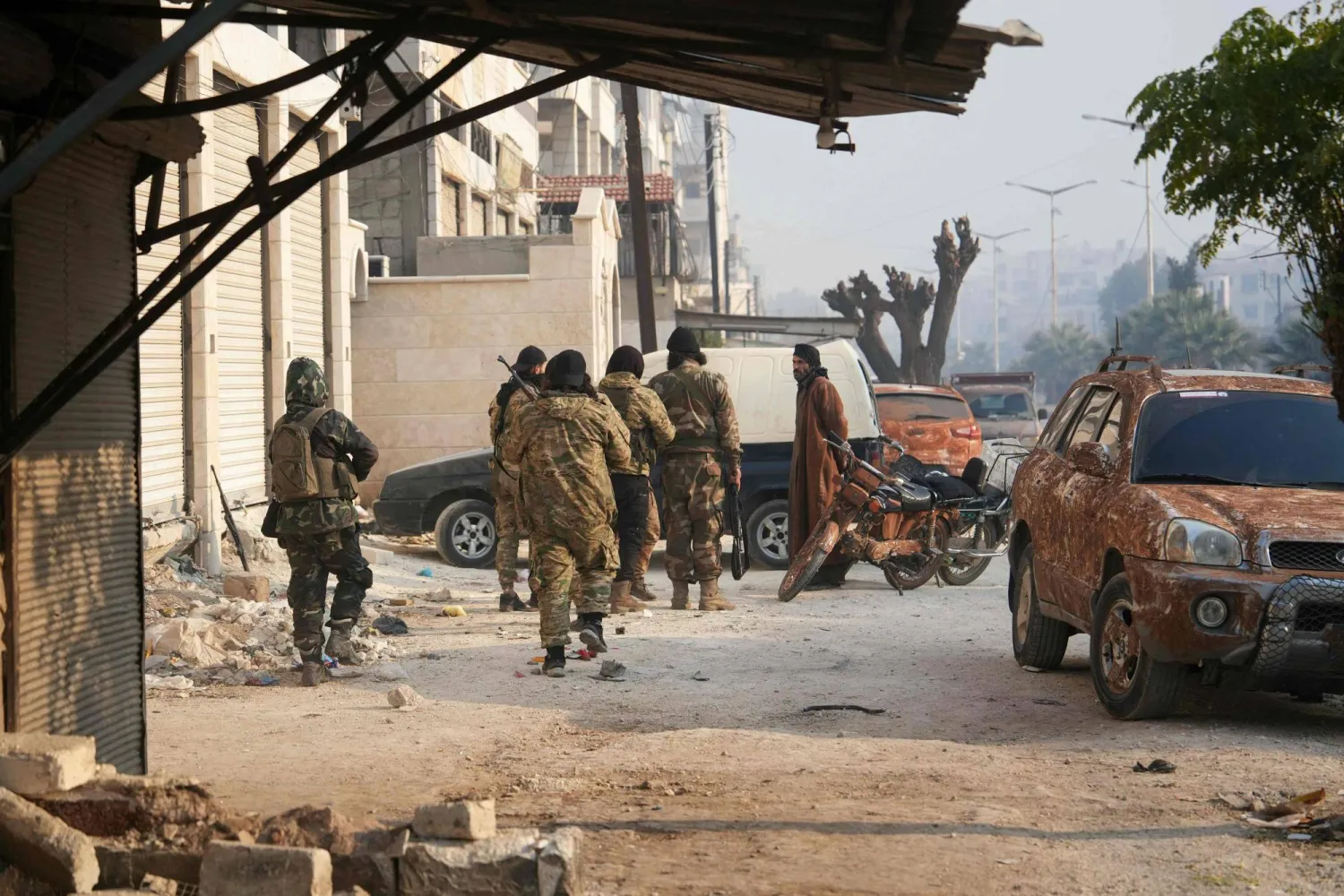 Syrian anti government fighters patrol the captured central-west city of Hama on December 6, 2024. (Photo by MUHAMMAD HAJ KADOUR / AFP)