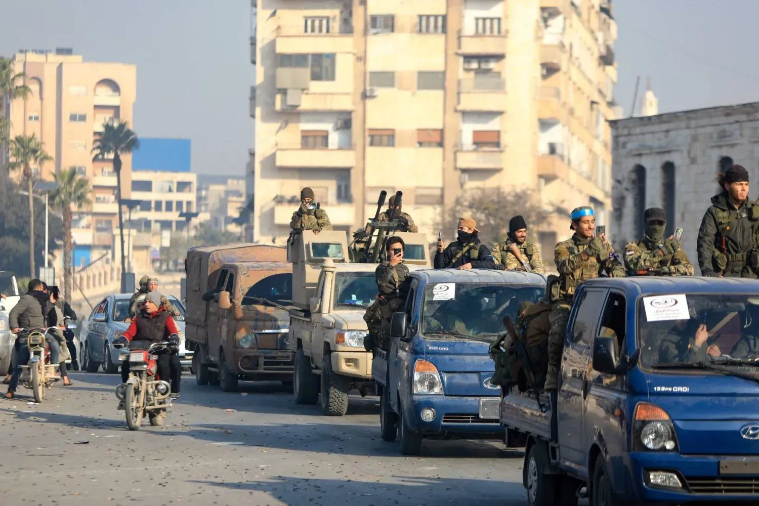 Şehrin kontrolünü ele geçirdikten sonra Hama'da kutlama yapan muhalifler (AFP)