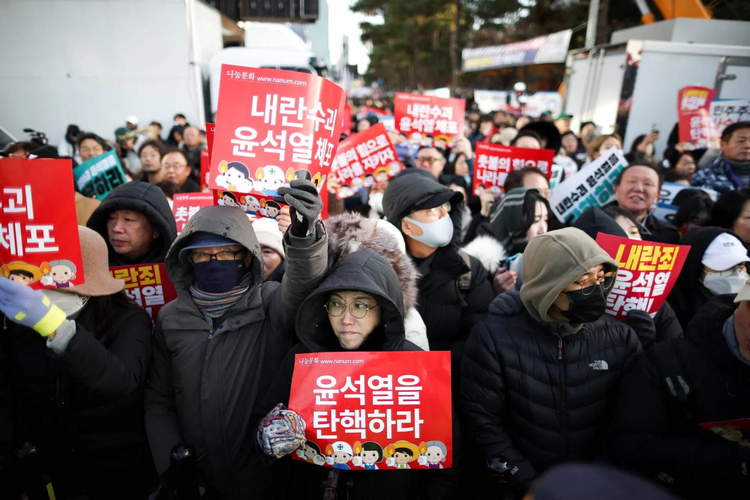 Protesters hold placards as they take part in a rally calling for the impeachment of South Korean President Yoon Suk Yeol, who declared martial law, which was reversed hours later, in front of the National Assembly in Seoul, South Korea, December 7, 2024. REUTERS/Kim Hong-ji