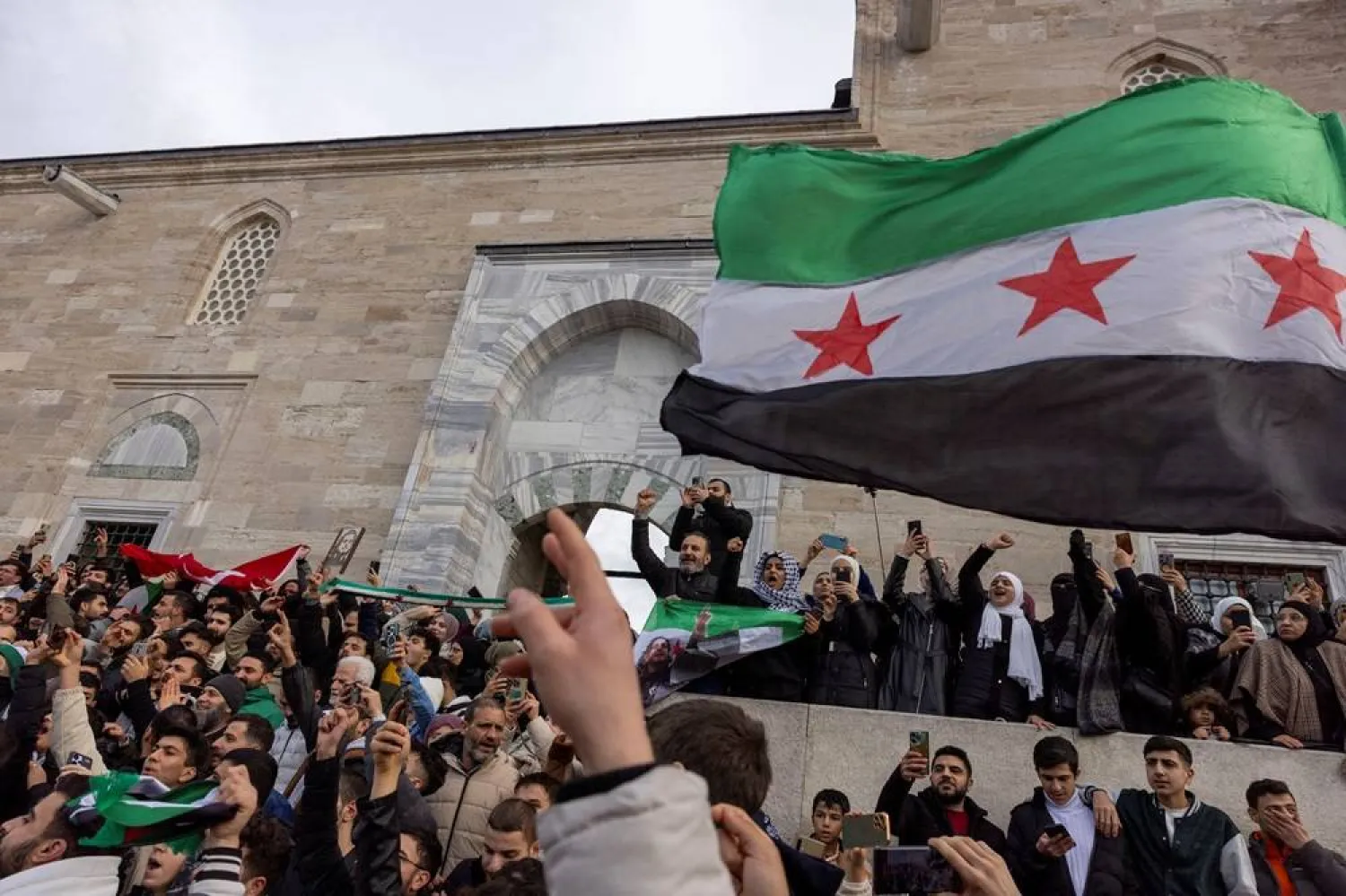 Syrians living in Türkiye celebrate with opposition flags after Syrian opposition fighters announced that they have ousted President Bashar al-Assad, in front of the Fatih Mosque in Istanbul, Türkiye, December 8, 2024. (Reuters) 