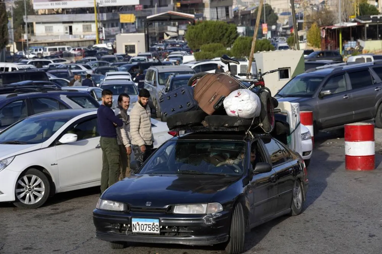  Syrians with their belongings queue as they cross to Syria through the Lebanese border crossing point of Masnaa, Bekaa Valley, Lebanon, Sunday, Dec. 8, 2024. (AP)