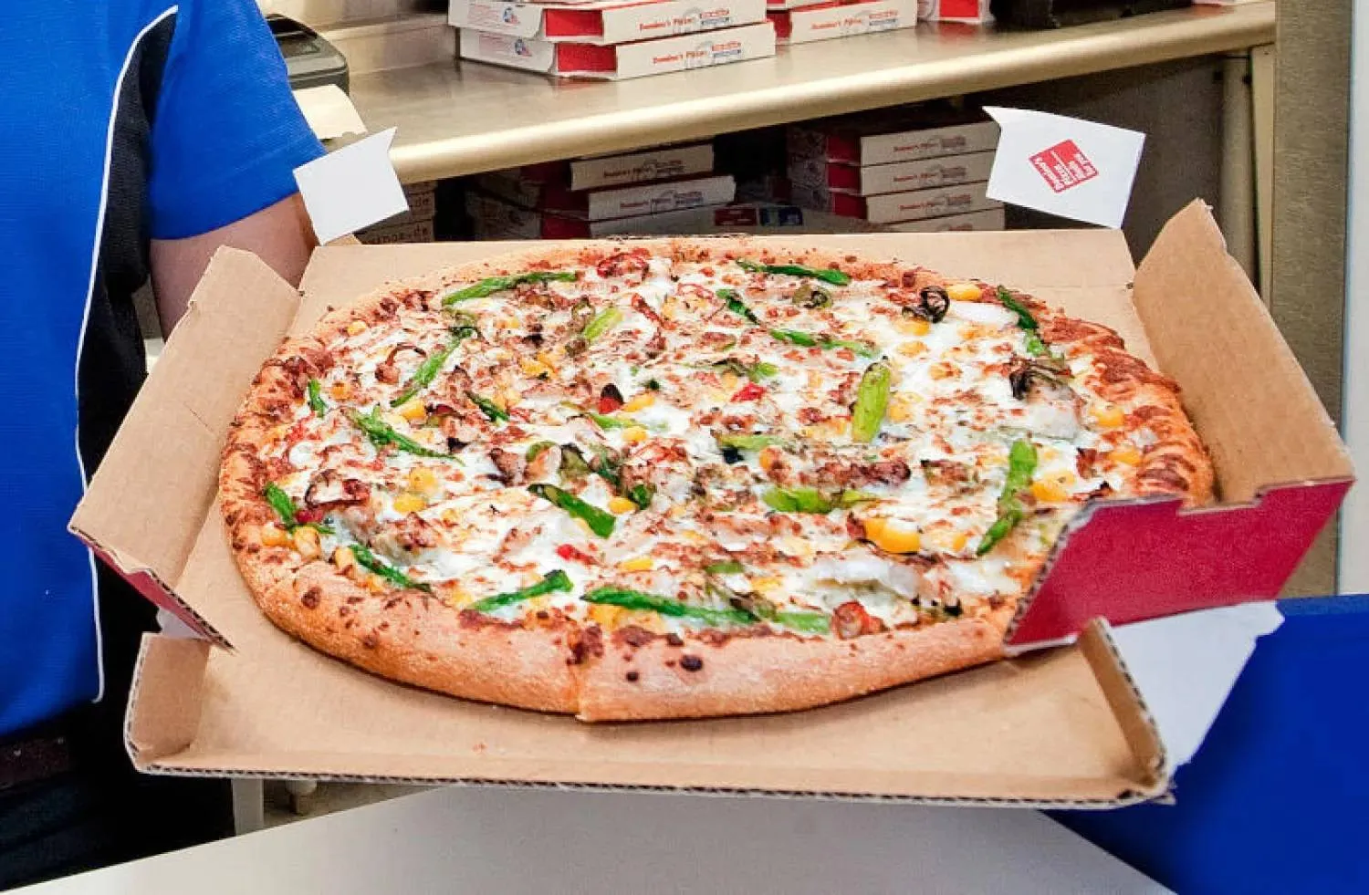 An employee carrying a pizza tray at a Domino's Pizza restaurant in Germany (DPA).



