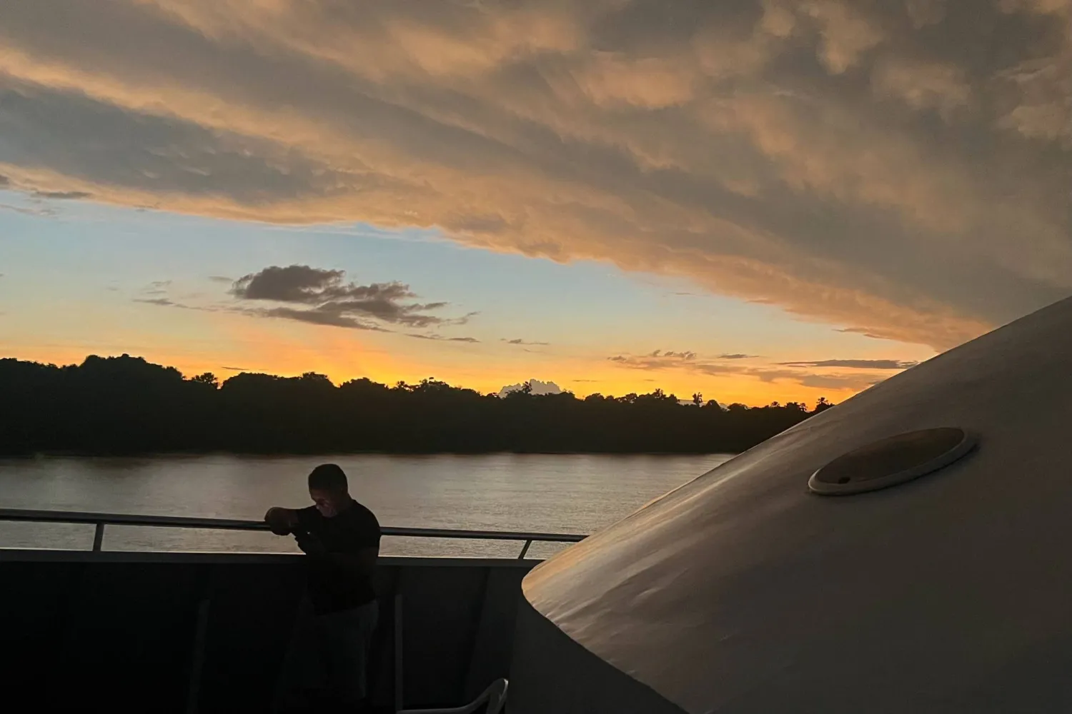 A man checks his cellphone after leaving the port of Breves in a boat in the Marajo region of the Brazilian Amazonia, Para State, Brazil, on December 9, 2024. (Photo by Pablo PORCIUNCULA / AFP)