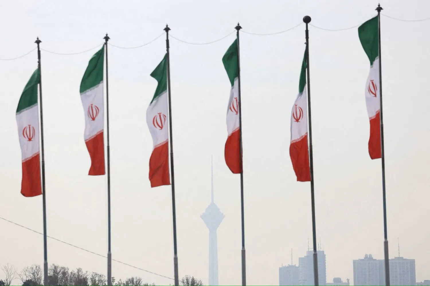 Iranian flags flutter as the Milad Tower is covered in smog following the increase in air pollution in Tehran, Iran December 8, 2024. Majid Asgaripour/WANA (West Asia News Agency) via REUTERS/File Photo
