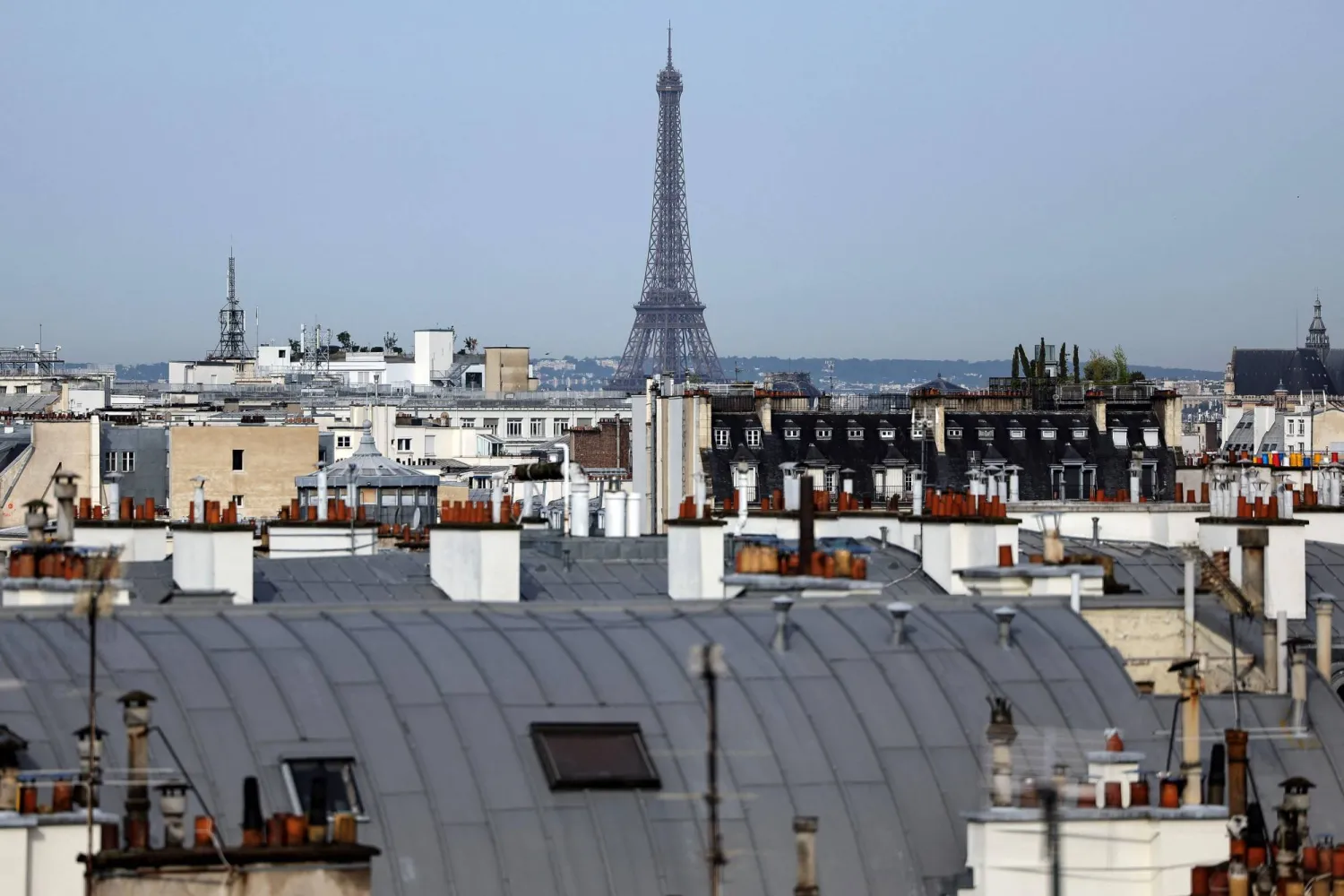(FILES) A photo shows a view of the Eiffel Tower from the rooftops of Paris, on July 31, 2024. (Photo by Valentine CHAPUIS / AFP)