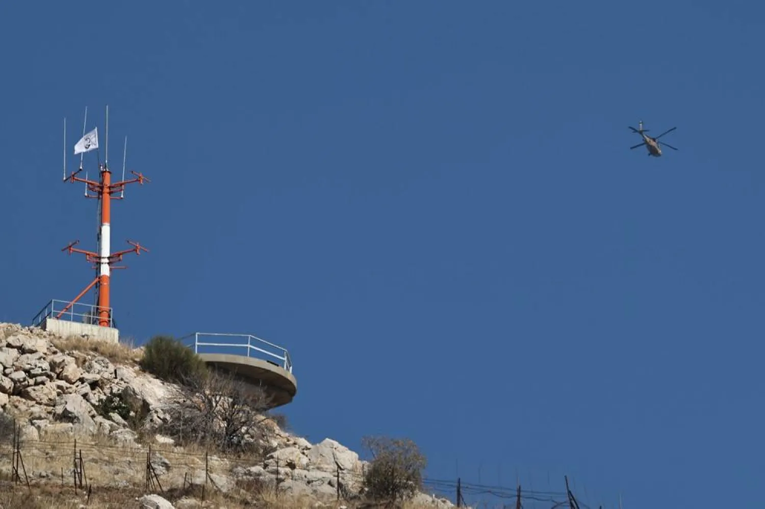 An Israeli military helicopter flies over Mount Hermon on the border between Israel and Syria in the Israeli-occupied Golan Heights, 17 December 2024. (EPA) 