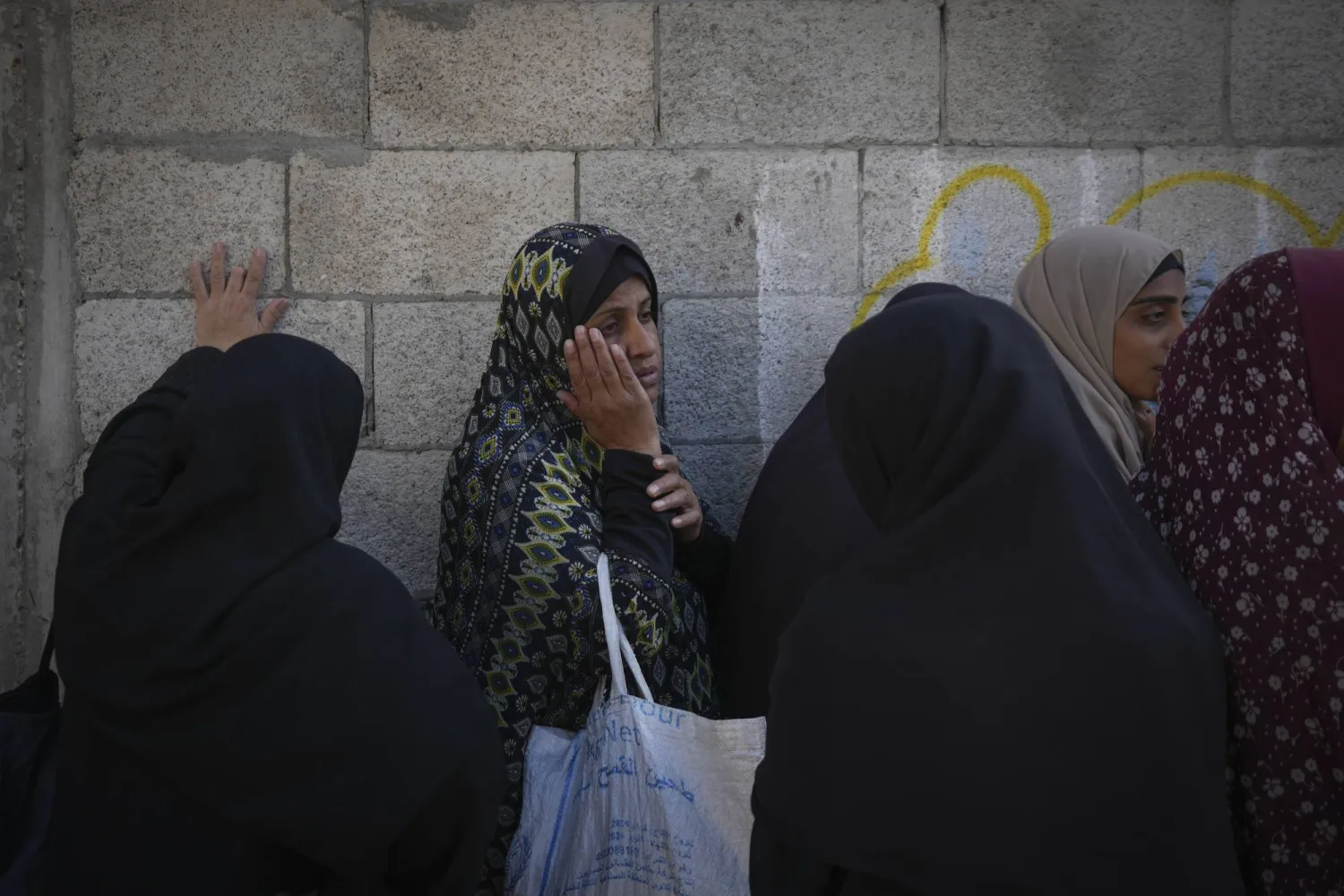 امرأة فلسطينية تنتظر في طابور للحصول على طعام في مركز بغزة (أ.ب)