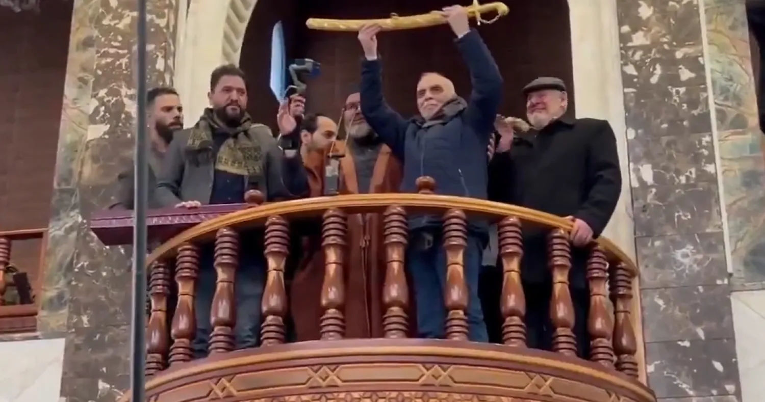 لقطة من فيديو متداول على مواقع التواصل الاجتماعي تُظهر رغيد الططري وهو يحمل سيفاً ذهبياً في حماة (إكس)