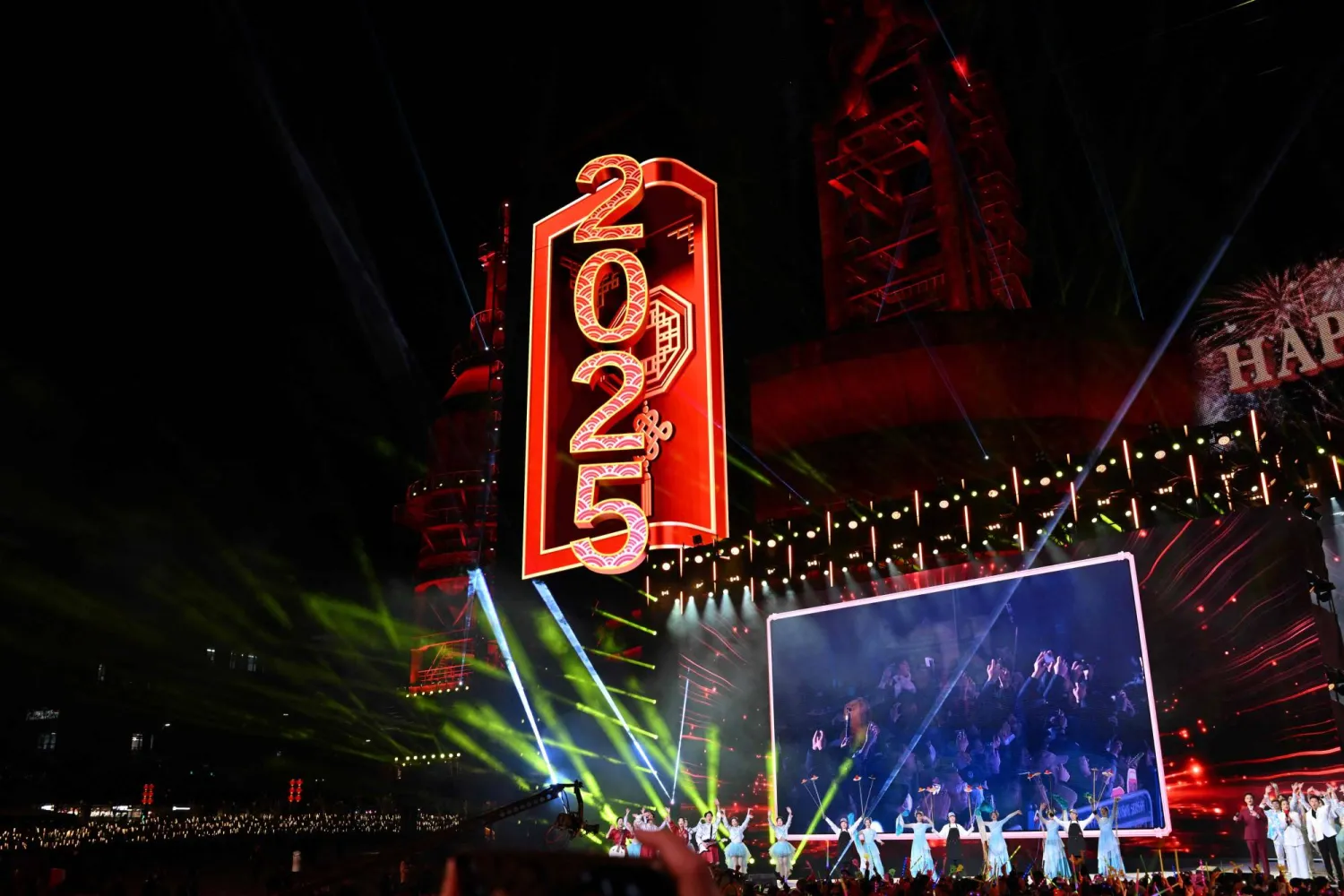 راقصون يؤدون عروضاً خلال احتفالات العد التنازلي للعام الجديد في بكين (أ.ف.ب)