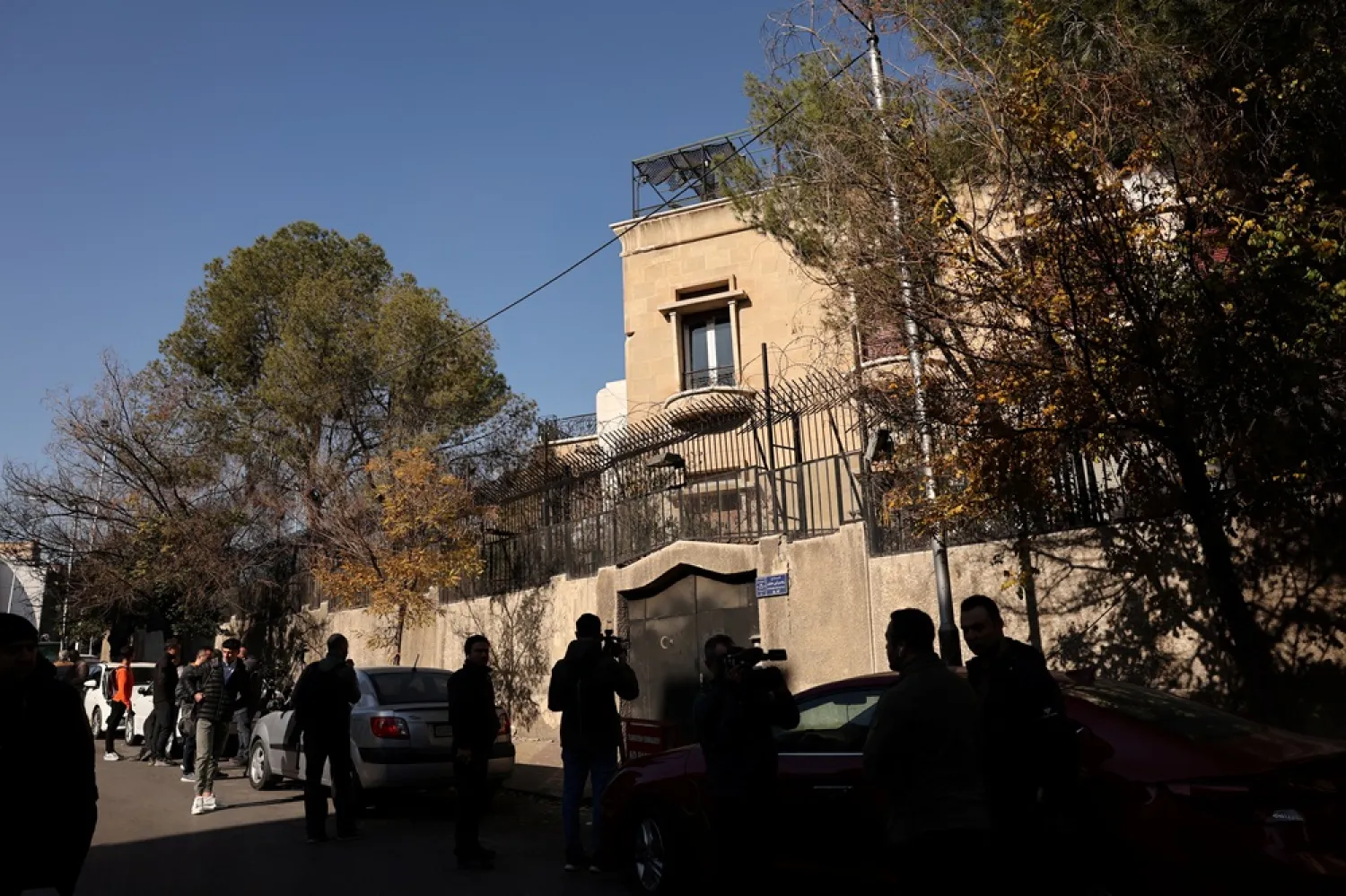 People stand near the Turkish Embassy, after fighters of the ruling Syrian body ousted Syria's Bashar al-Assad, in Damascus, Syria, December 14, 2024. (Reuters) 