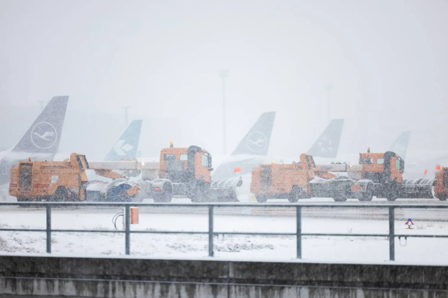 مركبات تمر لإزالة الثلوج أمام الطائرات المتوقفة في مطار فرانكفورت (د.ب.أ)