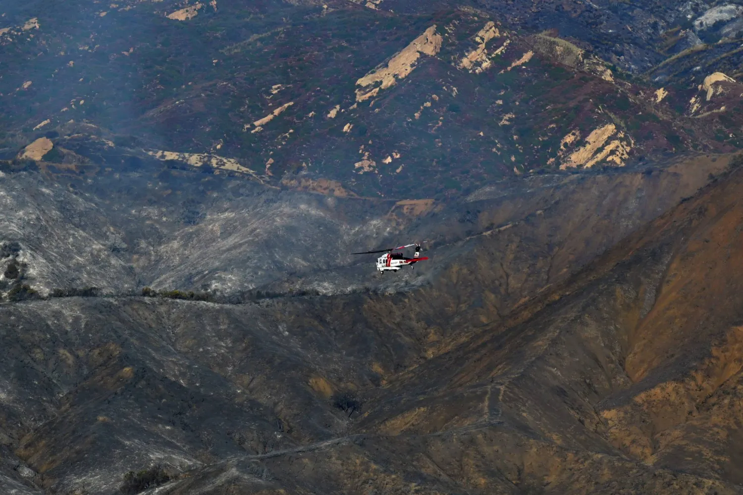 مروحية تحلق فوق التلال التي أحرقها حريق باليساديس... وهو مجتمع في غرب مقاطعة لوس أنجليس (أ.ف.ب)
