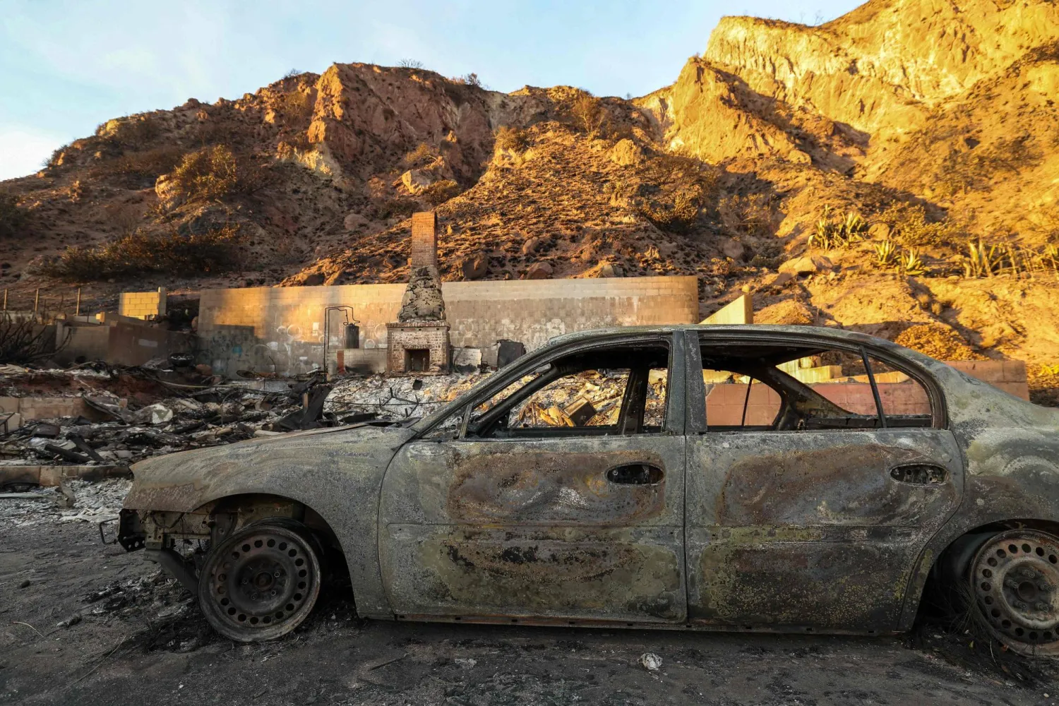 تظهر السيارات المحترقة والمنازل المدمرة بسبب حريق باليساديس على طول طريق ساحل المحيط الهادئ في ماليبو بولاية كاليفورنيا (أ.ف.ب)